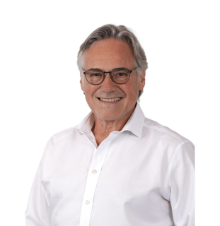 Älterer Mann mit weißem Hemd vor neutralem Hintergrund